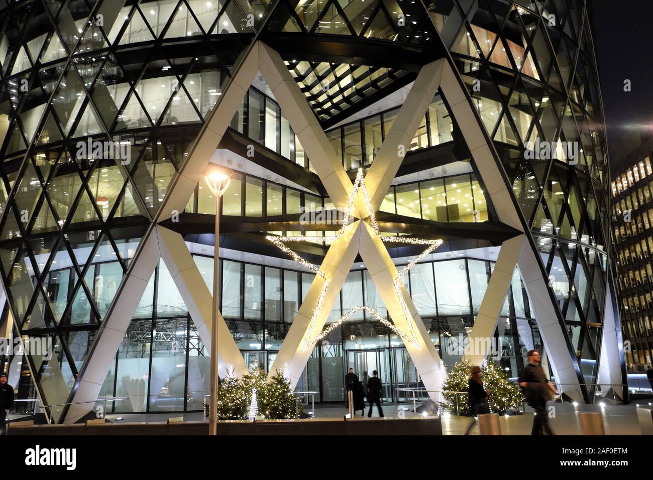Christmas trees and star decoration outside the entrance to the gherkin skyscraper building in the financial district City of London UK  KATHY DEWITT Stock Photo