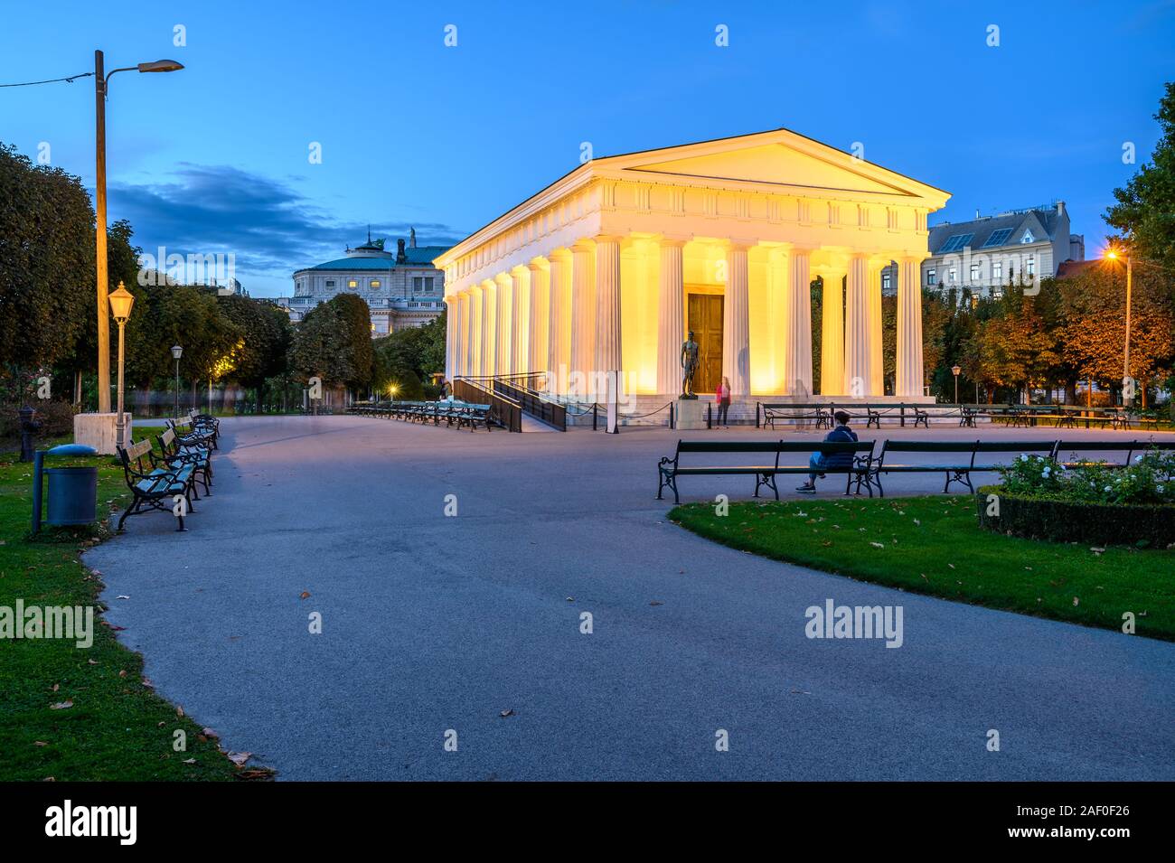Landscape of white Column Hall in beautiful garden Volksgarten, Wien. Facade of portico in public park among green bushes, hedge and flowers Stock Photo