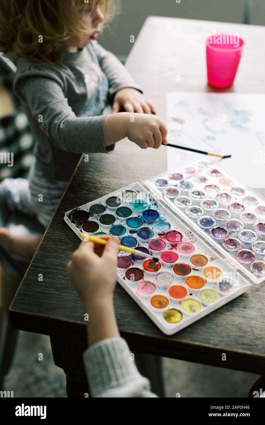 Children spending an afternoon painting with watercolors. Stock Photo