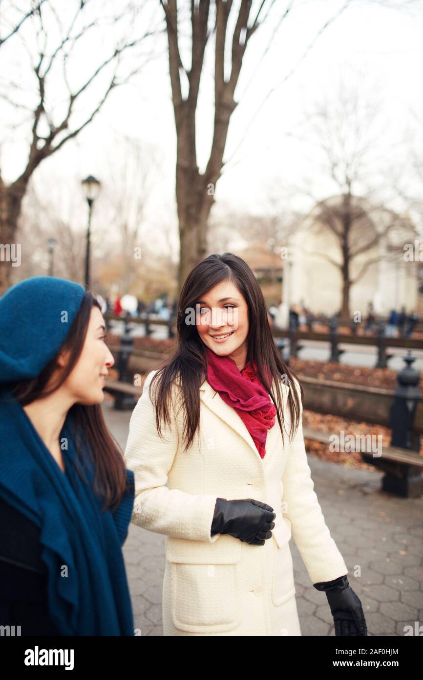 Friends walking and talking in city park in winter Stock Photo