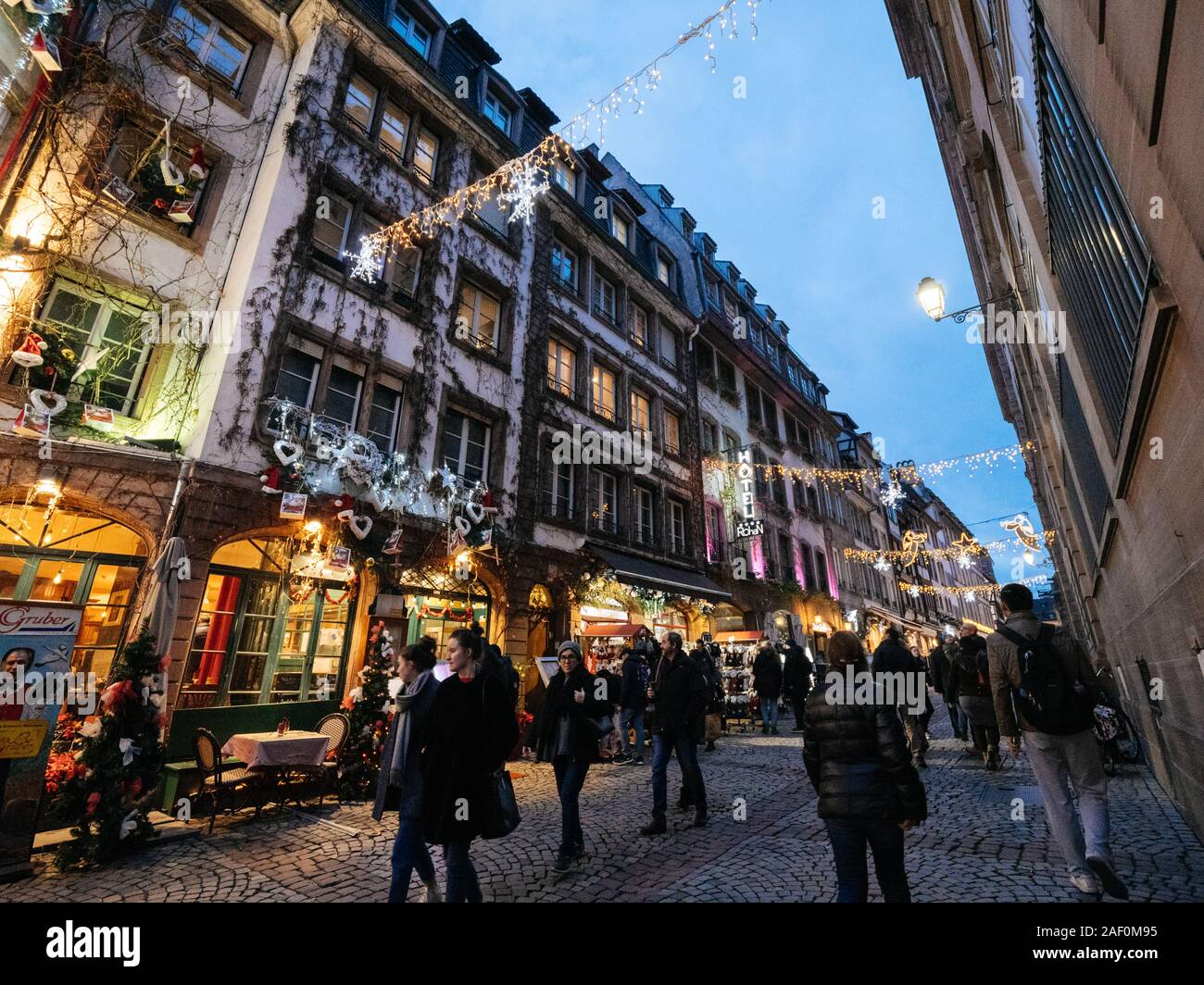 Strasbourg, France - Dec 24, 2018: Wide anlge view of vibrant pedestrian iconic with tourists people walking discovering the annual Christmas Market decorations and Palais Rohan hotel in background Stock Photo