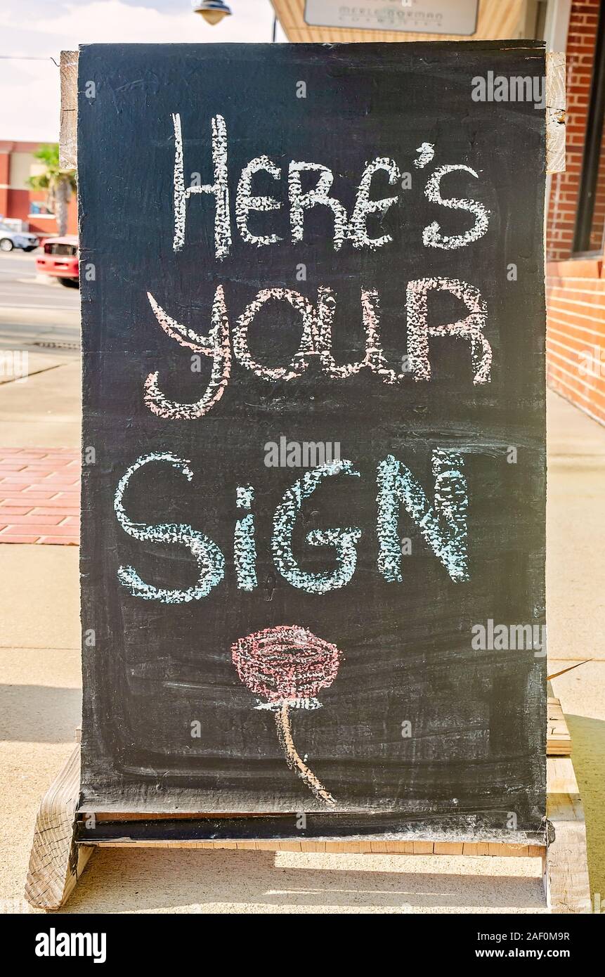 A chalkboard sign in front of a shop states “Here’s your sign” in downtown Port St. Joe, Sept. 18, 2019, in Port St. Joe, Florida. Stock Photo