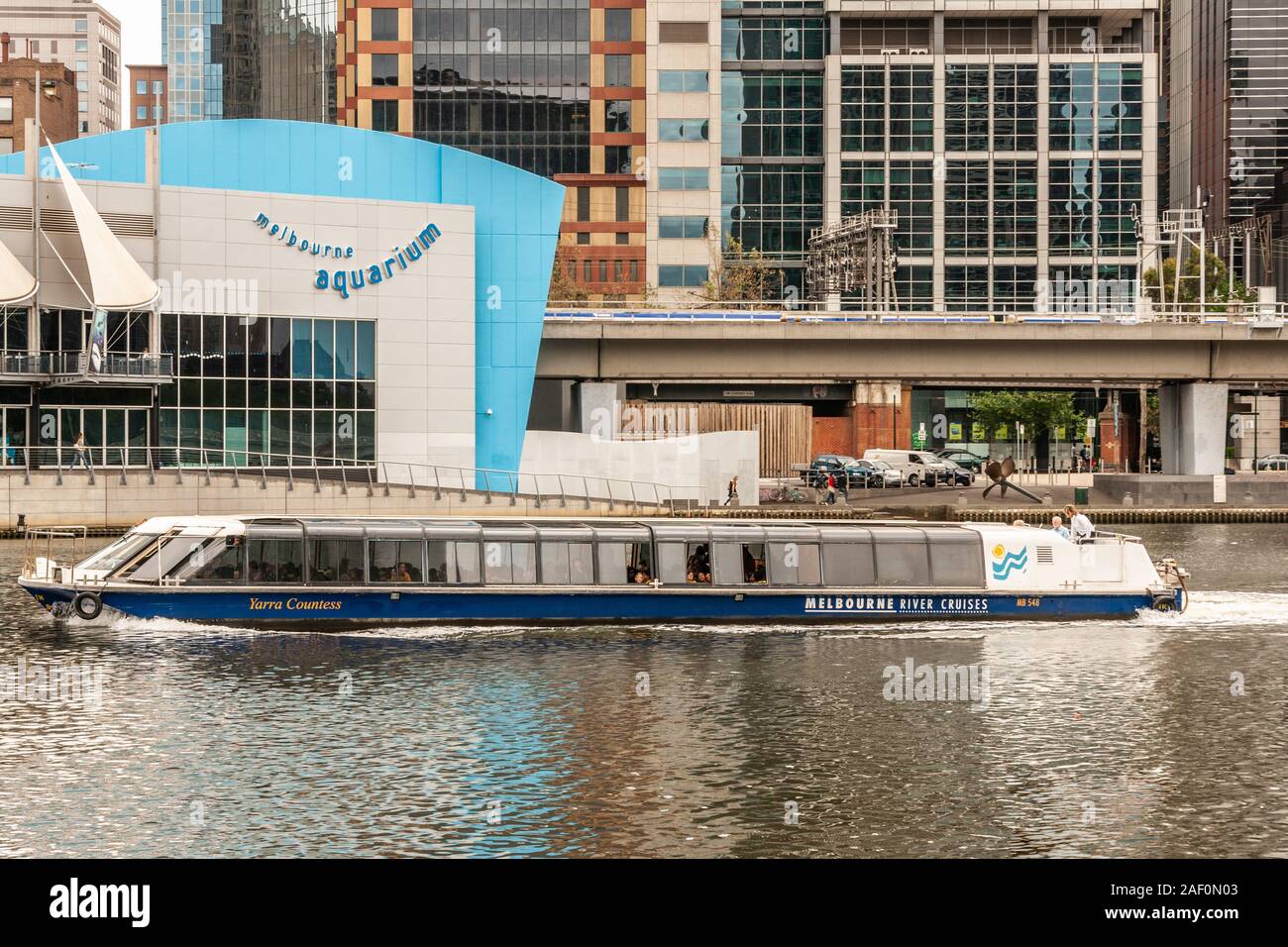 Melbourne, Australia - November 16, 2009: Focus on blue-white Aquarium building front behind yarra river whereon the Yarra Countess river cruise boat Stock Photo