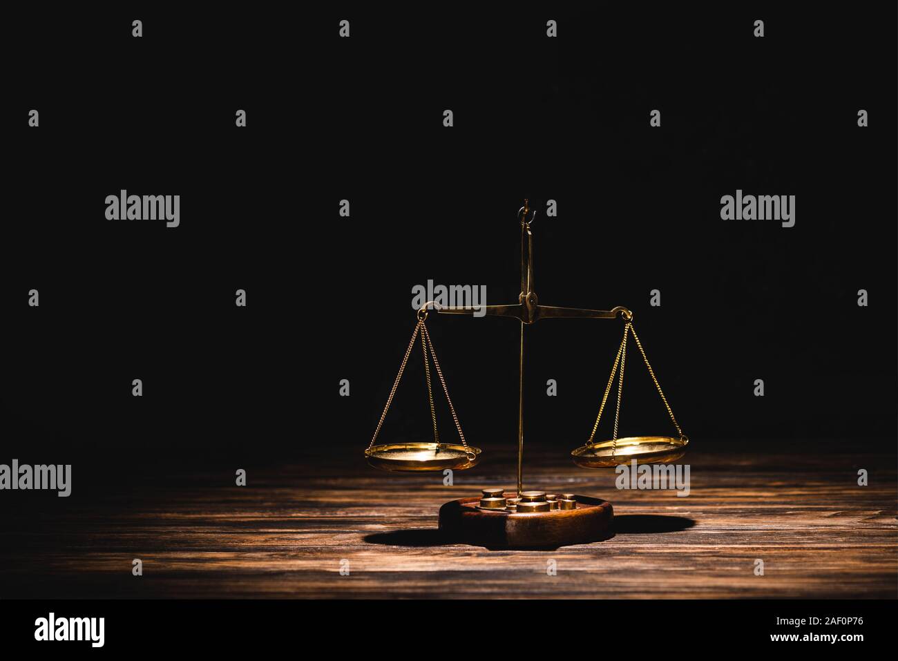 golden scales of justice on wooden table on black background Stock ...