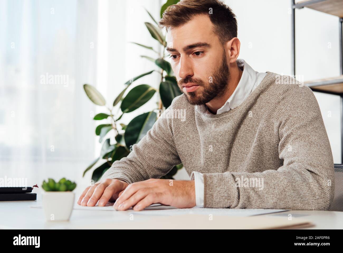 Blind man reading braille font at table Stock Photo