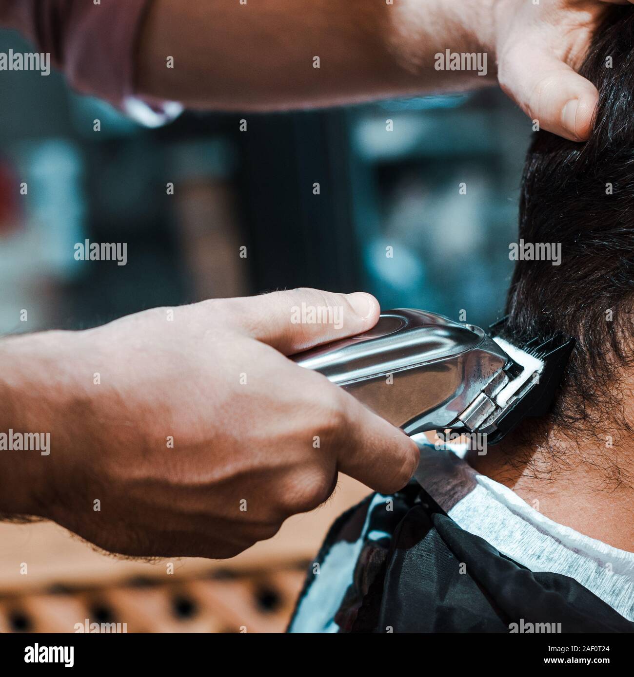 close up of barber styling hair of man in barbershop Stock Photo
