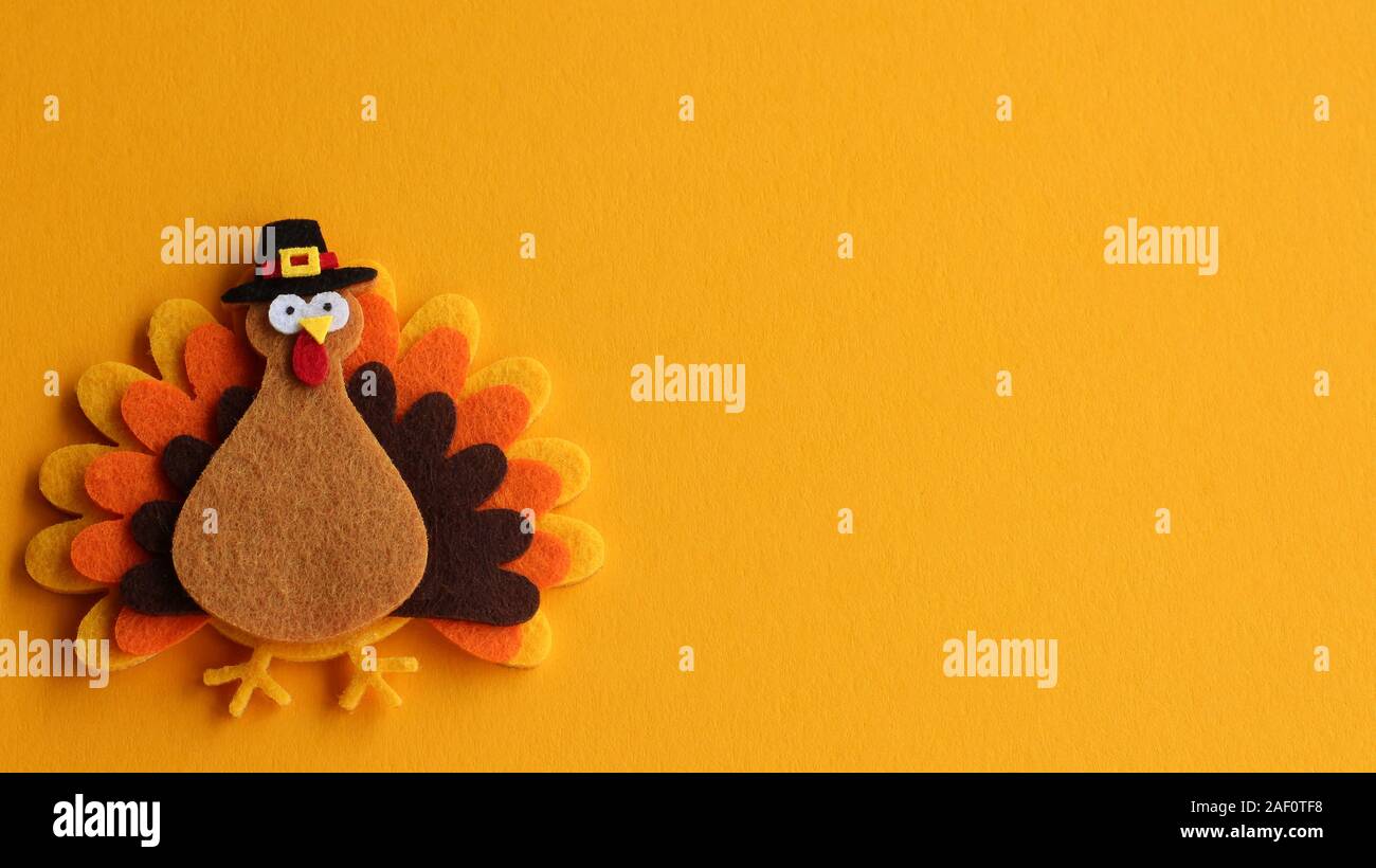 craft felt orange brown and tan turkey with pigrim hat on an orange background with writing space Stock Photo