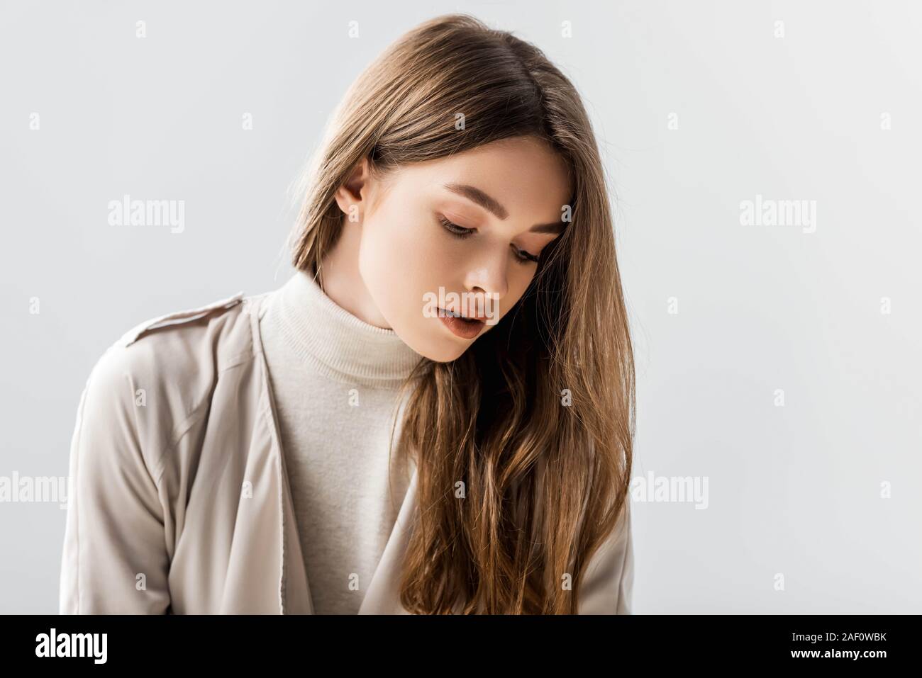 dreamy, stylish woman looking down isolated on grey Stock Photo