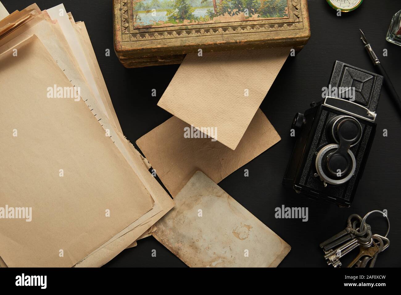 top view of vintage camera, paper, painting, fountain pen, keys on ...