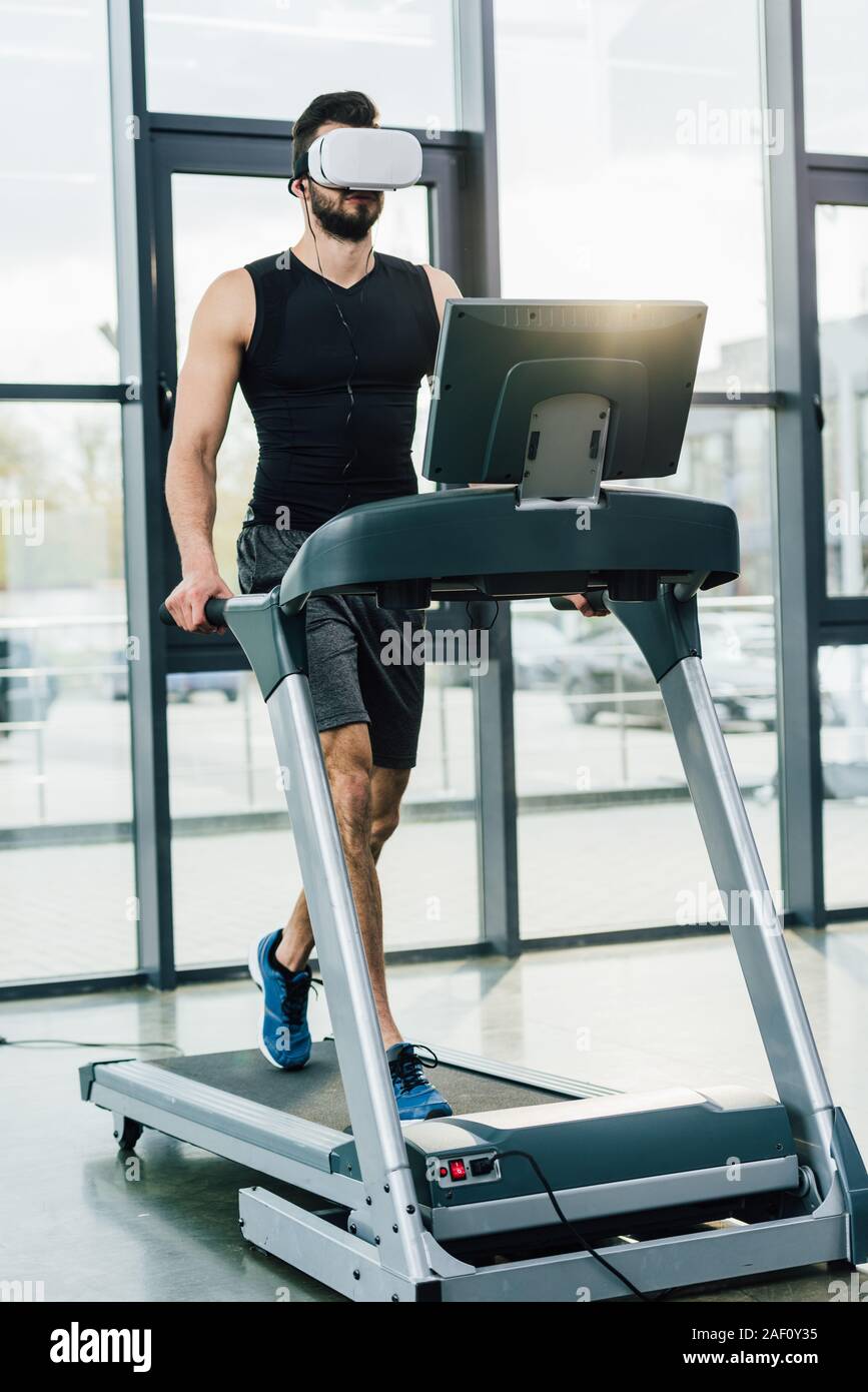 sportsman in virtual reality headset running on treadmill at sports center  Stock Photo - Alamy