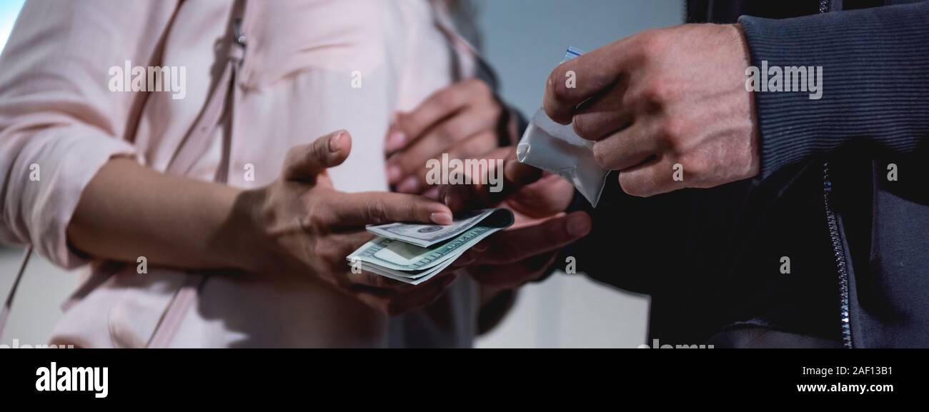 panoramic shot of woman with dollar banknotes buying drugs from thug Stock Photo
