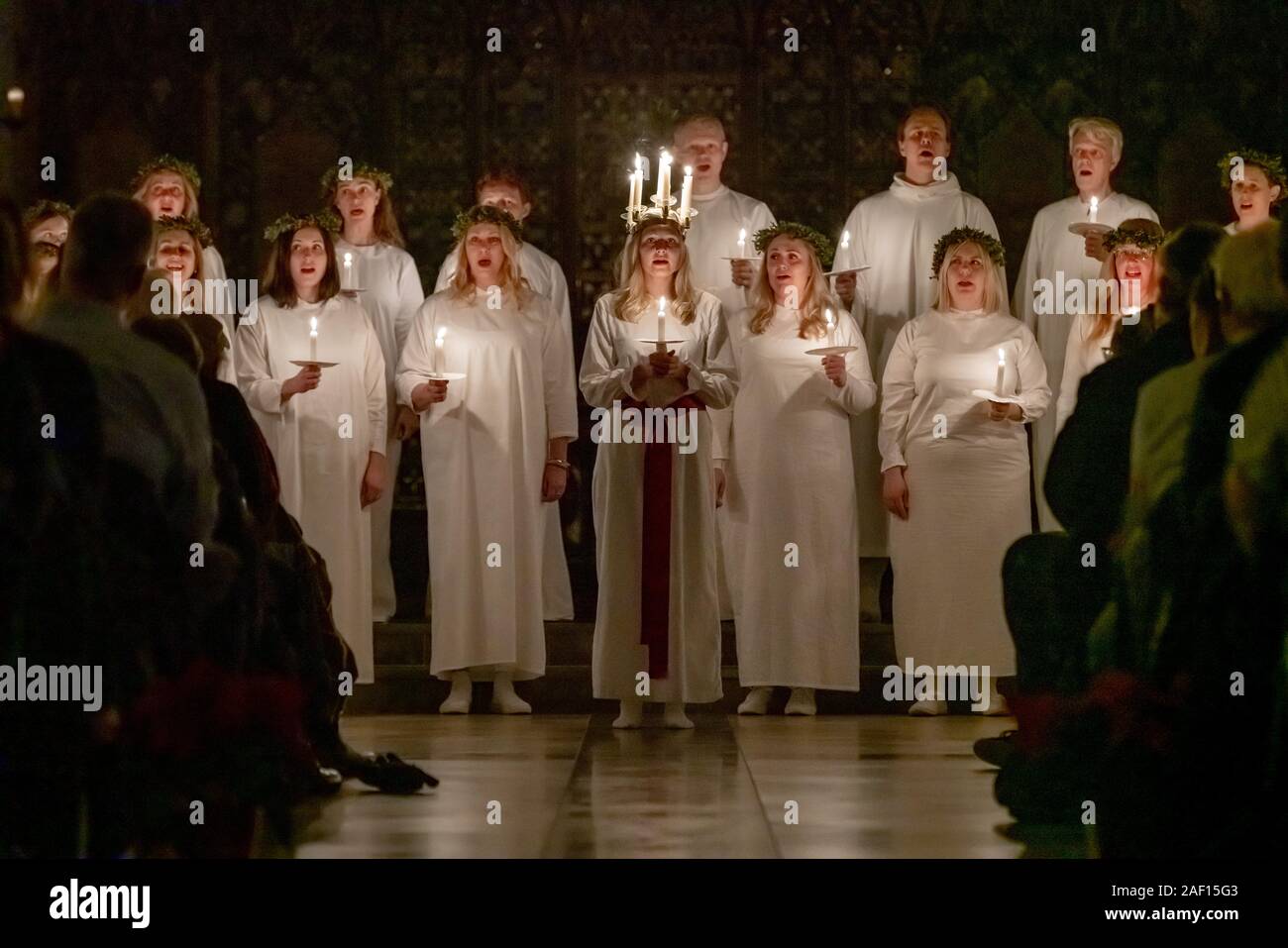 London, UK. 11th December, 2019. Liv Palmblad, from Sweden, playing the role of Lucia, leads the procession during the London Nordic Choir’s traditional Scandinavian ‘Sankta Lucia’ concert at St John’s Church near Hyde Park. The service features a candlelit procession of choristers led by a girl, Lucia, wearing a crown of candles and a red sash around her waist. Credit: Guy Corbishley/Alamy Live News Stock Photo