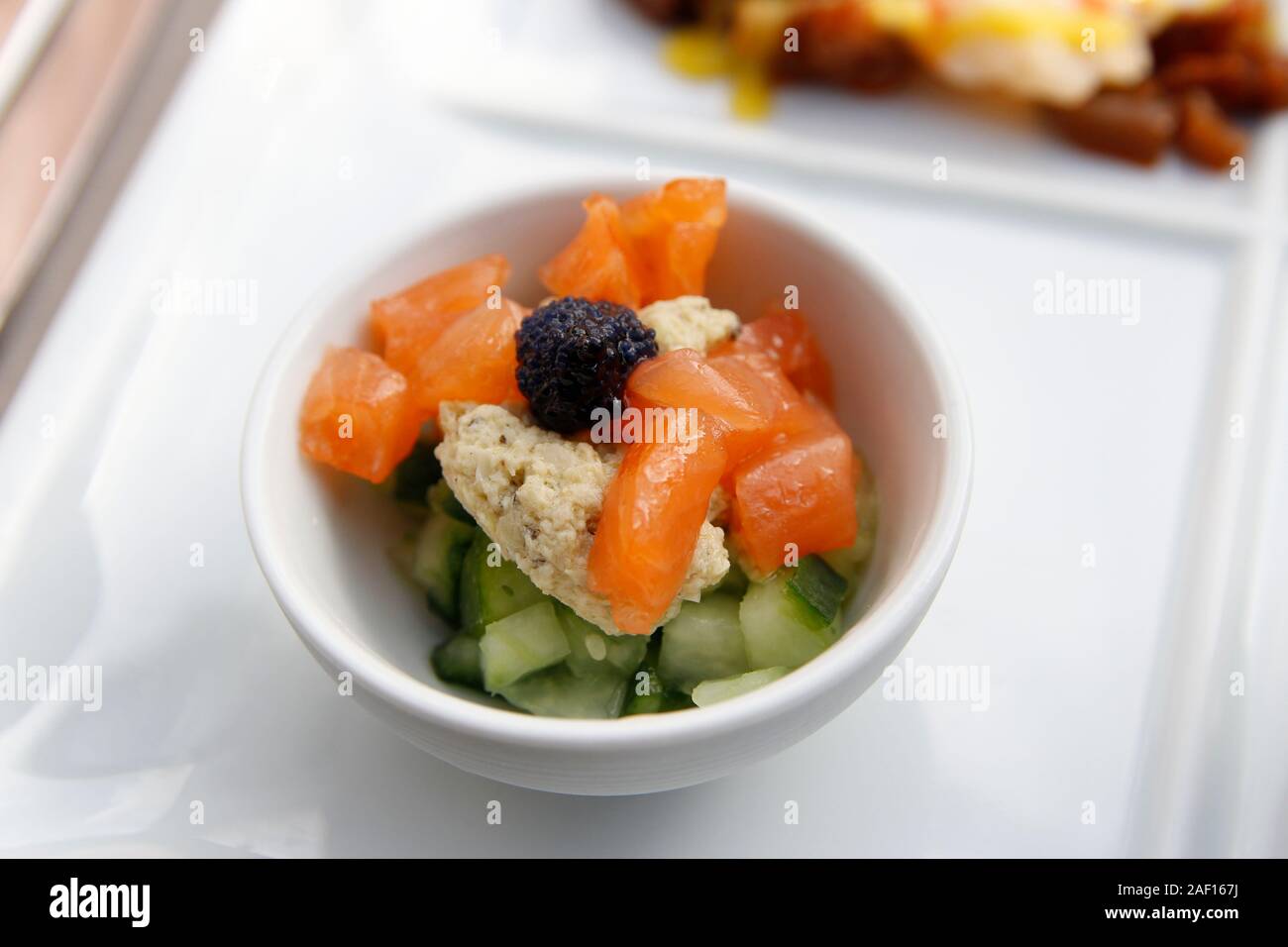 Focus on the diced smoke salmon with lumpfish roe, cucumber and artichoke tartare as the starter for dinner in Paris Stock Photo