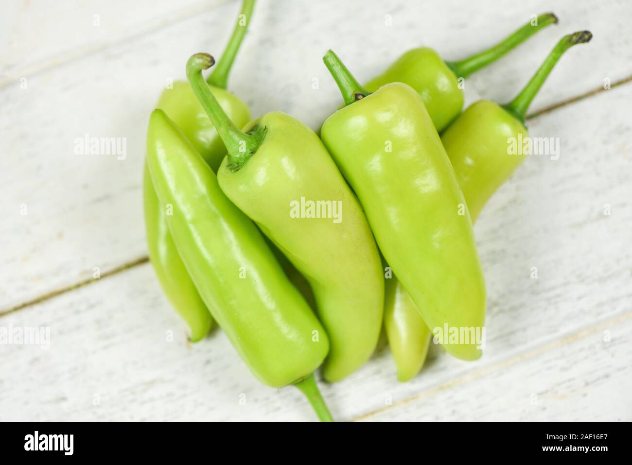 Fresh banana peppers or sweet pepper green garden on a white wooden