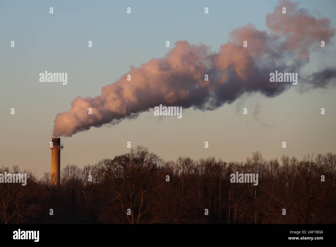 Smoke and steam coming from the smoke stack of a factory Stock Photo