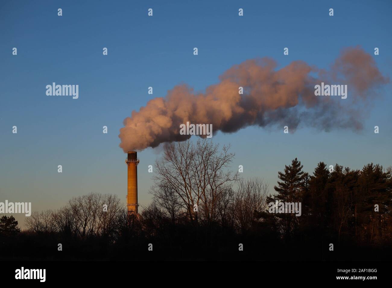 Smoke and steam coming from the smoke stack of a factory Stock Photo