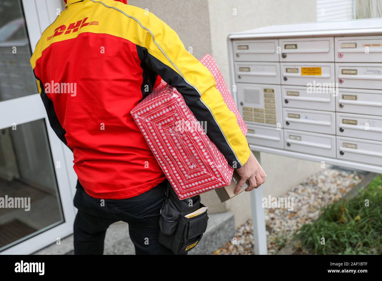 Halle Germany 11th Dec 19 A Dhl Parcel Delivery Service Waits With Shipments Under Its Arm At A Front Door In Paulusviertel Dhl Expects A New Record Number Of Parcels For The