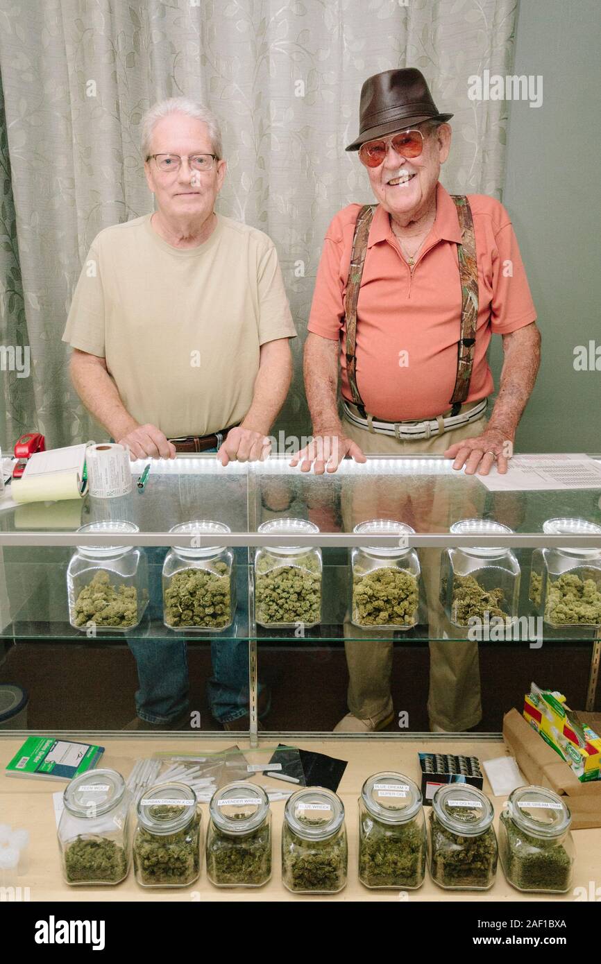 Two senior citizens at the counter of their medical marijuana dispensary Stock Photo