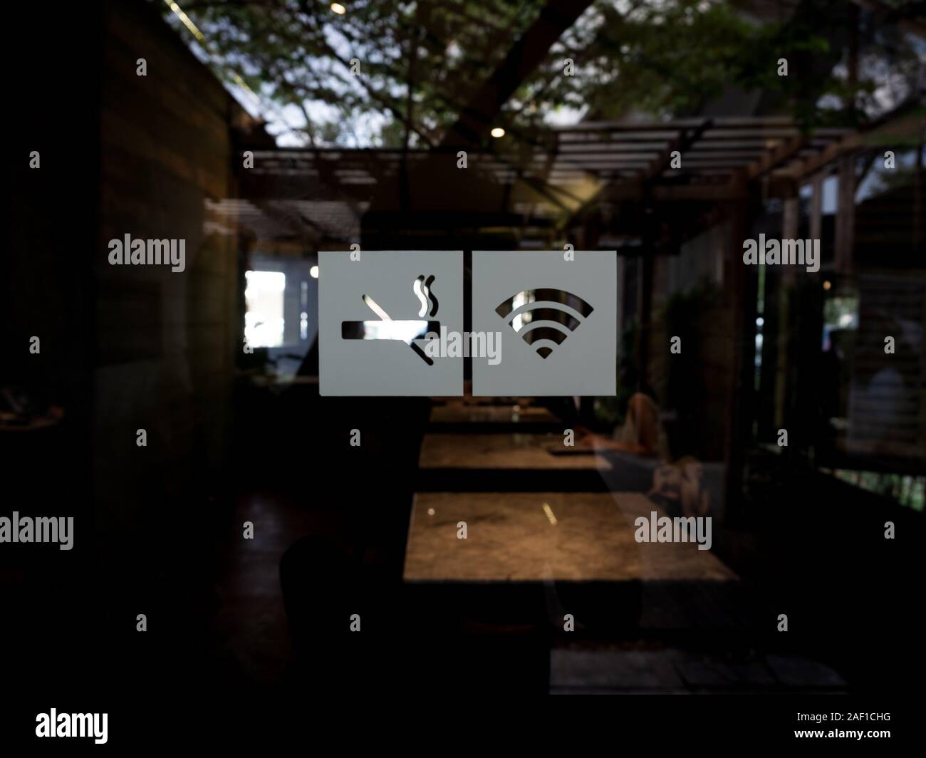 Blurred Background Of Signs On Glass Door No Smoking Sign Wireless Signal Icon Sign For Free Wifi On Cafe Background Decal Sticker Signs Pasted On Stock Photo Alamy