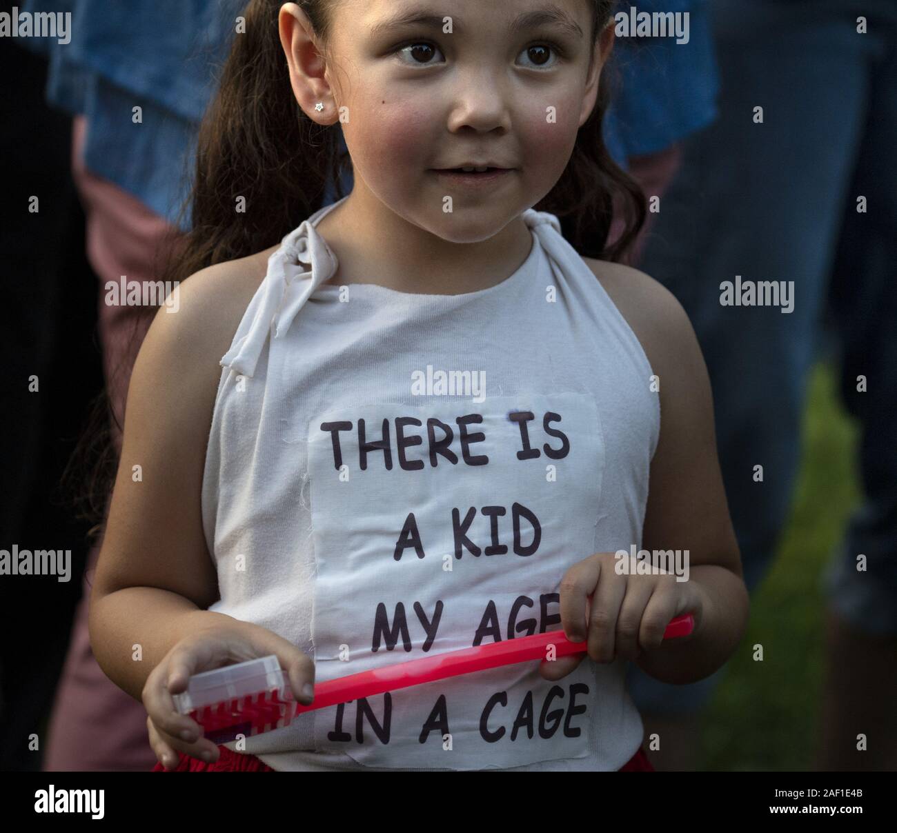 Washington, United States. 12th Dec, 2019. A small child joins hundreds of protesters voicing their opinion to the human detention camps on the United States-Mexico border during 'Lights for Liberty' rally in Lafayette Square across the street from the White House in Washington, DC on Friday, July 12, 2019. The rally was part of a nationwide protest against the treatment of immigrants in detention centers and to mark the deaths of eight refugee children in the camps or at the border. Photo by Pat Benic/UPI Credit: UPI/Alamy Live News Stock Photo