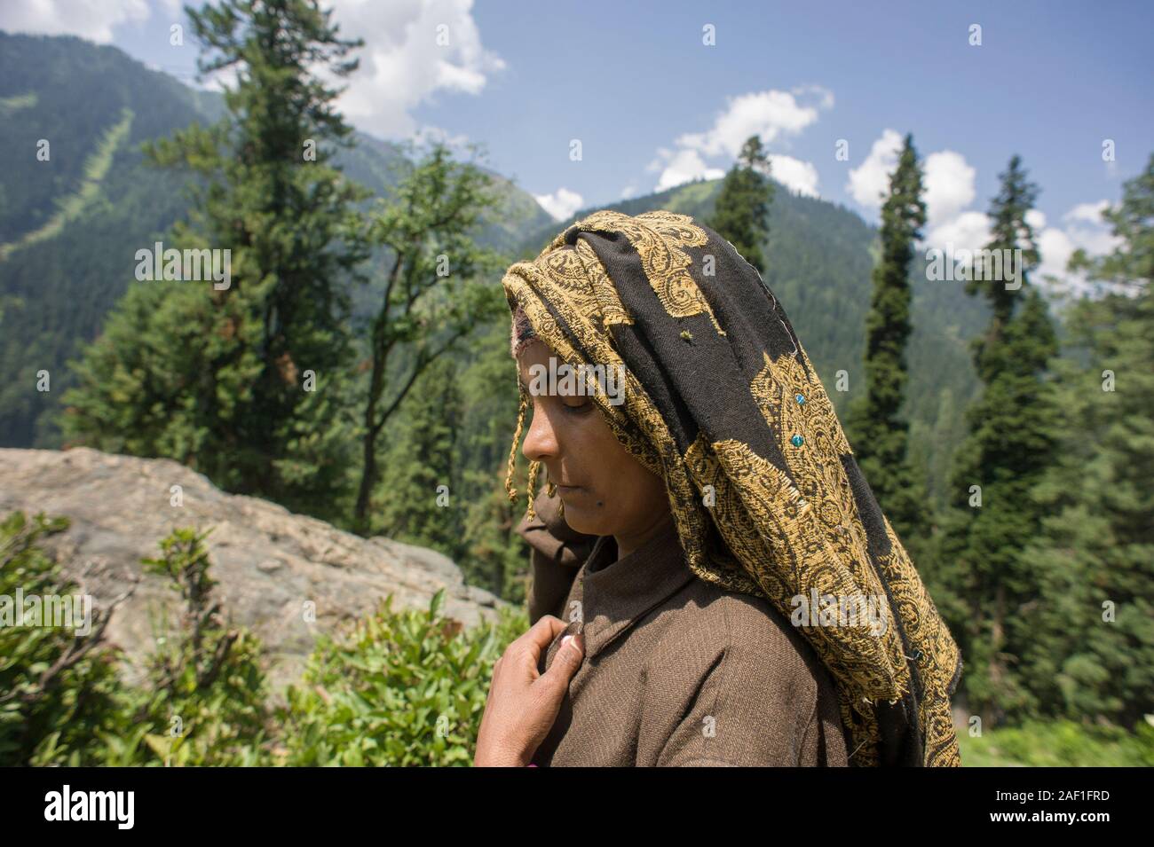 Pahalgam, Jammu and Kashmir, India - August 02, 2011: Profile portrait of gypsy woman of Gujjar ethnicity with eyes closed and hand on chest Stock Photo