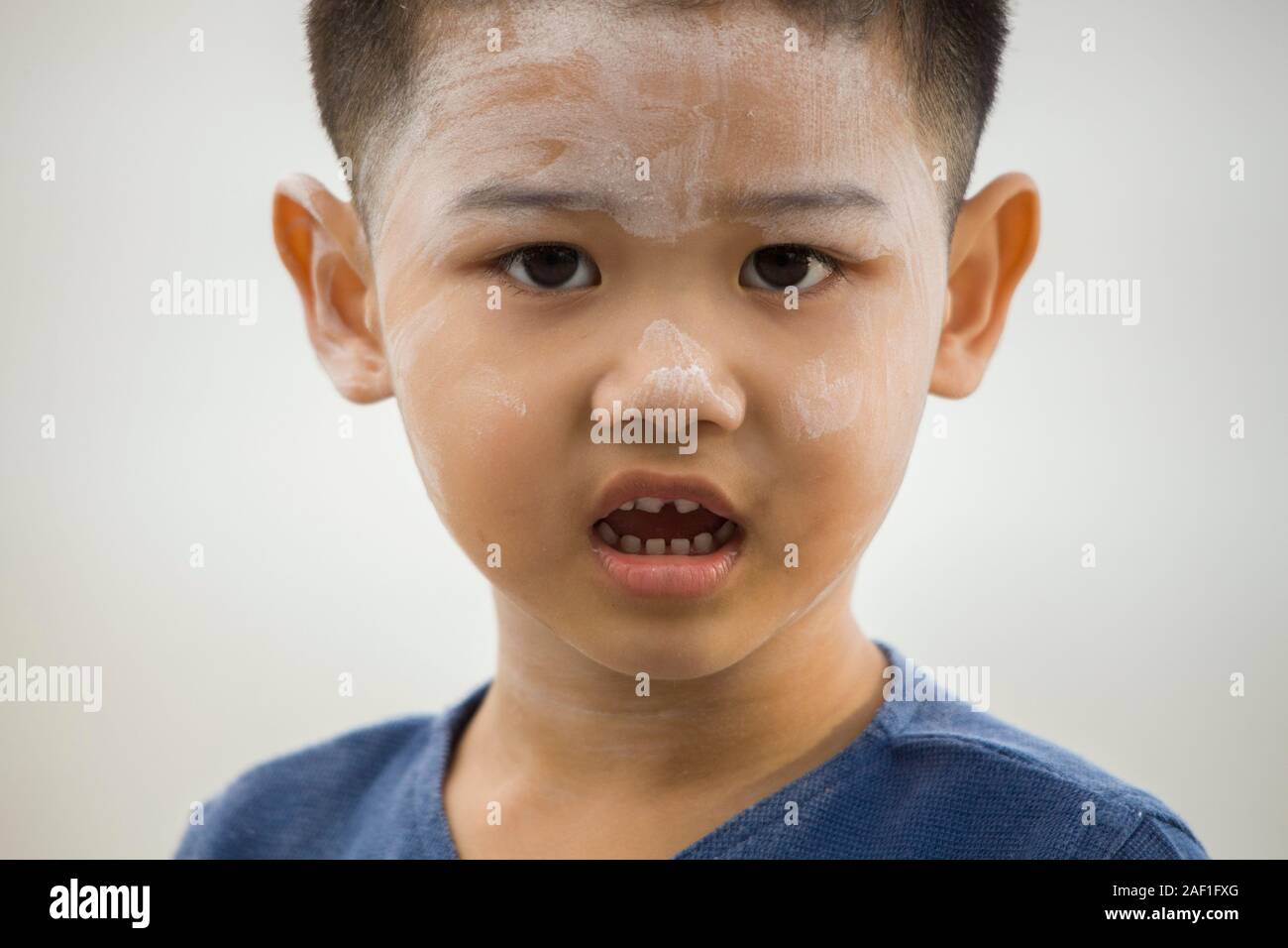 Bangkok, Thailand - December 13, 2010:  Cute little boy using the traditional Thanaka paste on face. The cosmetic it´s rich in E vitamin Stock Photo