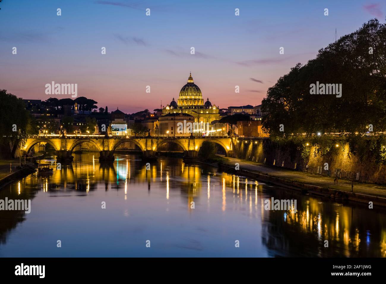 The Papal Basilica of St. Peter, St. Peter's Basilica and the bridge Ponte Sant'Angelo, illuminated at night, mirroring in the river Tiber Stock Photo