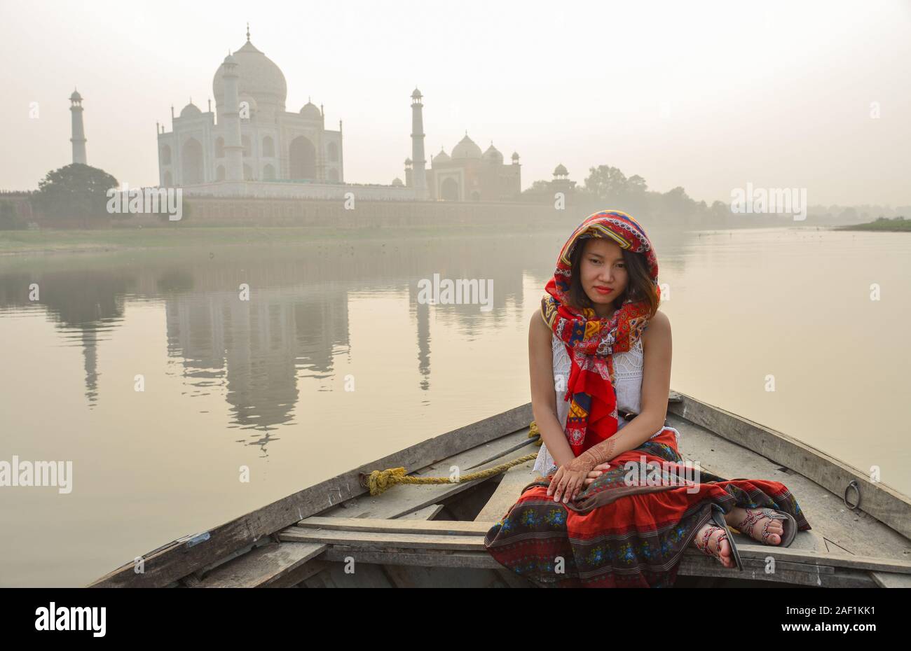 A woman watching sunset over Taj Mahal (Agra, India) from a wooden boat. Stock Photo