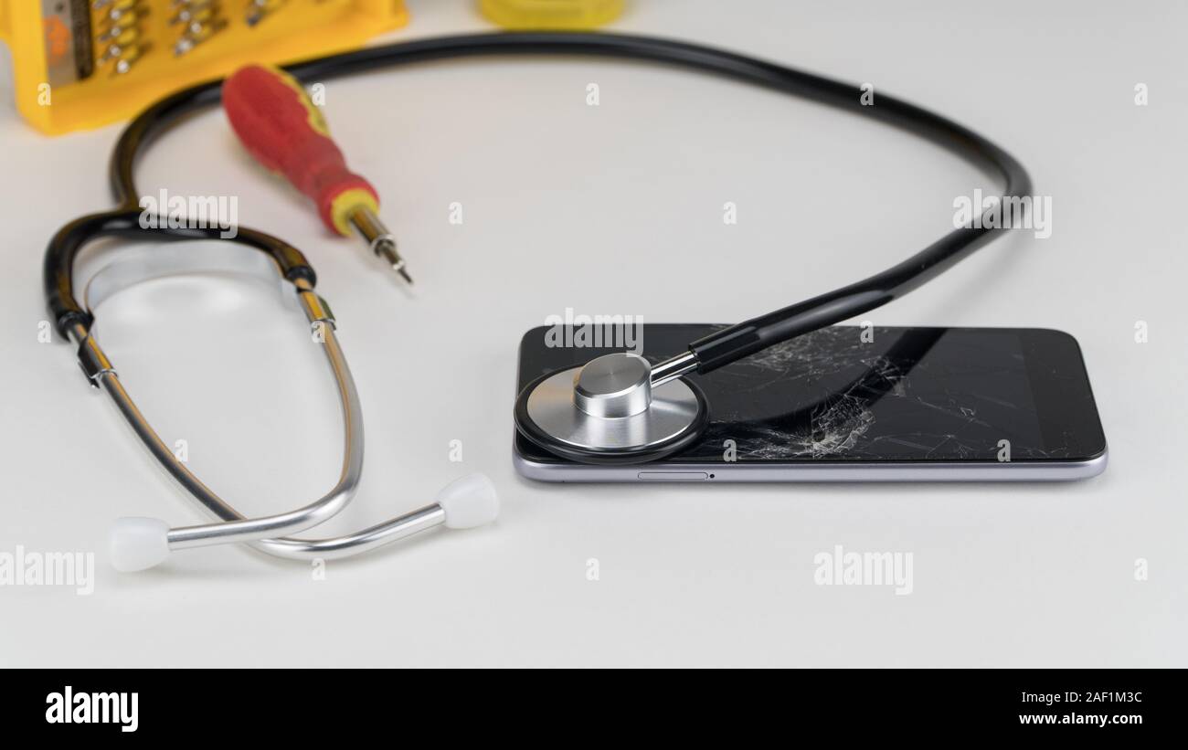 Diagnosing the phone with a stethoscope, near a screwdriver. Phone