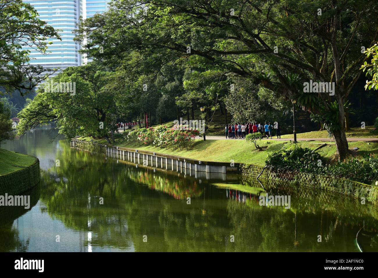 Group of people running at the Botanical Garden with skyscrapers in background. Kuala Lumpur Stock Photo