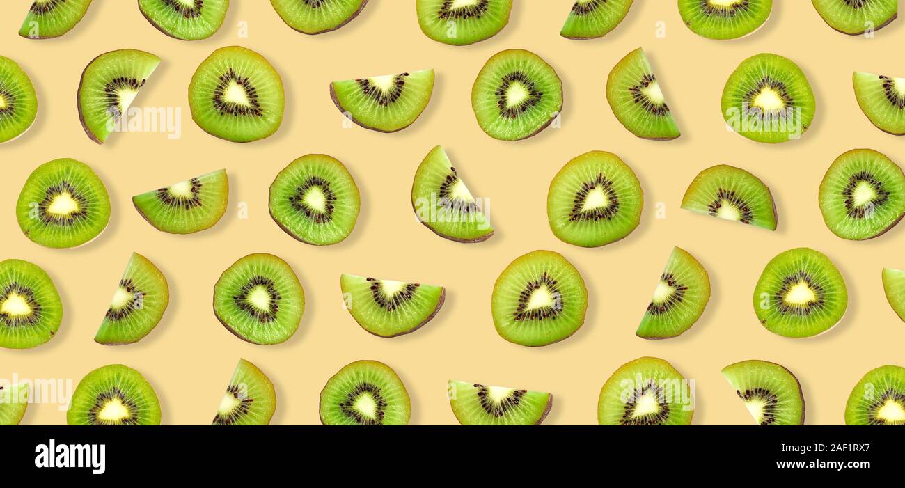 Kiwi fruit Slices macro. Ripe Kiwi fruit isolated on yellow background. Stock Photo