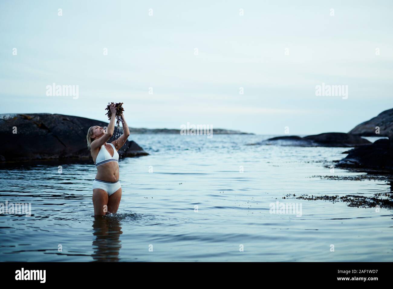 Woman standing in sea Stock Photo