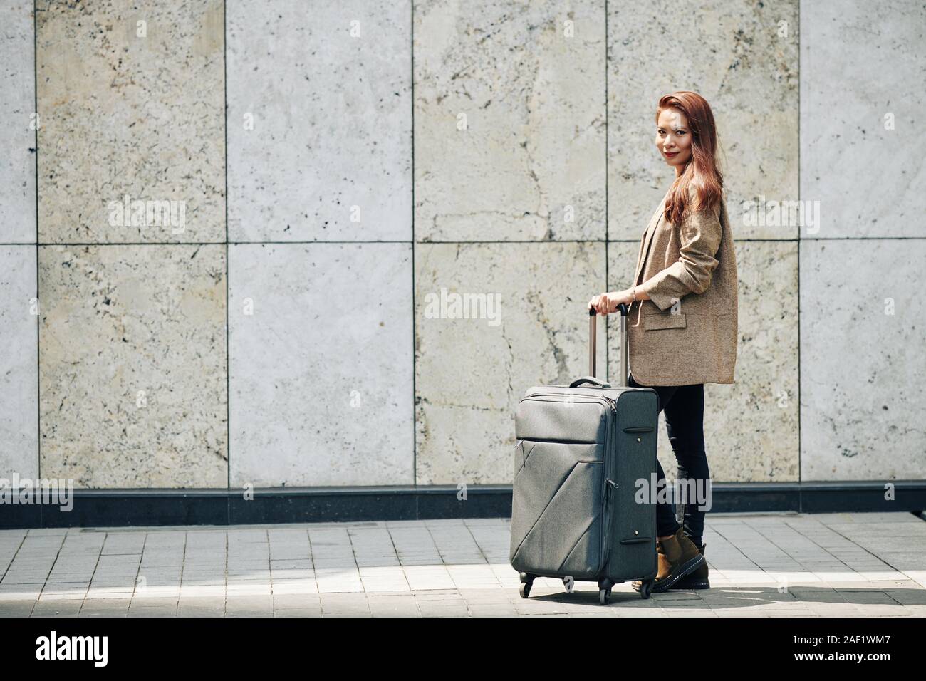 Beautiful Vietnamese woman in wool jacket standing in the street with