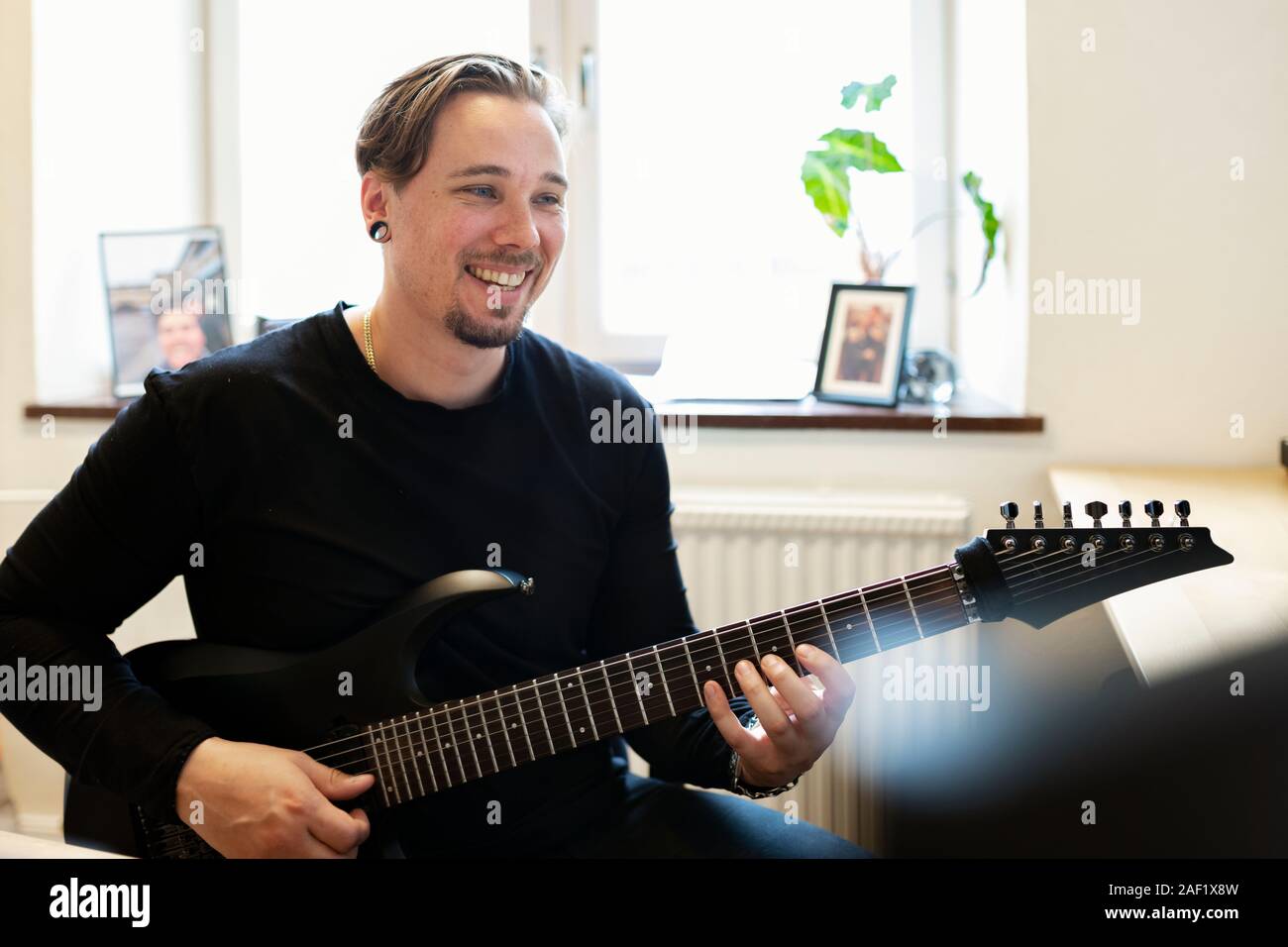 Smiling man playing electric guitar Stock Photo