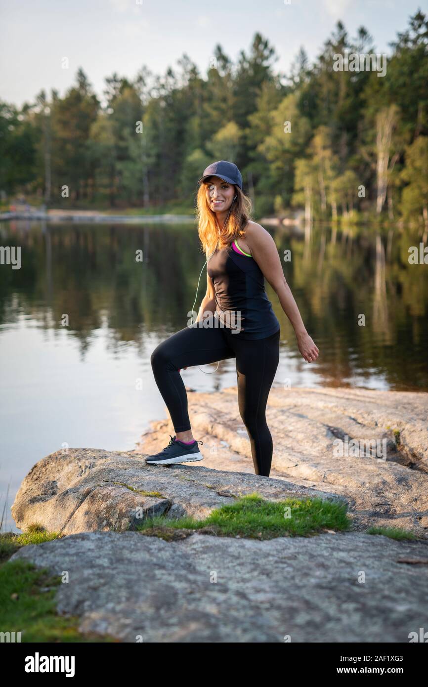 Woman at lake wearing sports clothes Stock Photo
