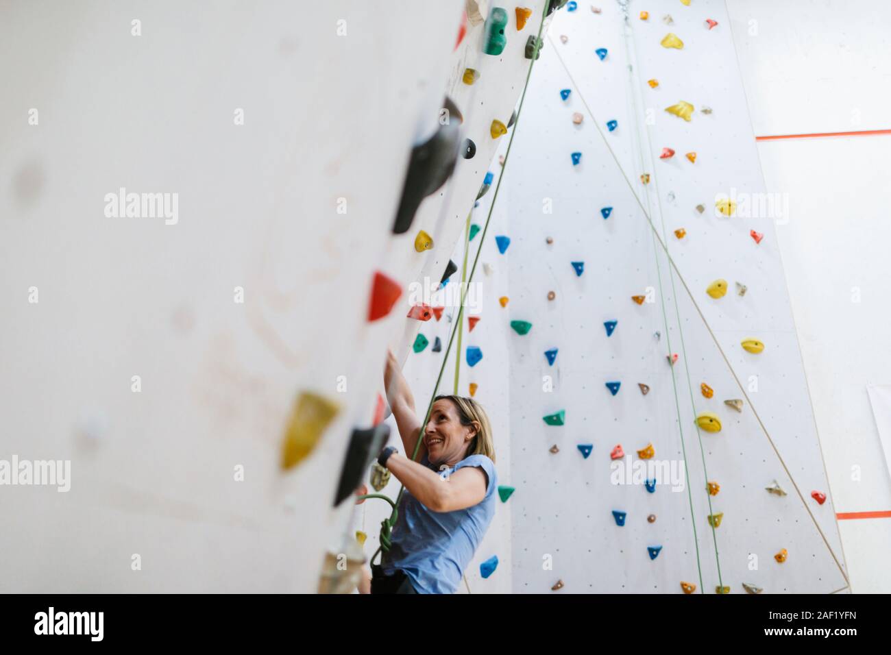 Woman on climbing wall Stock Photo