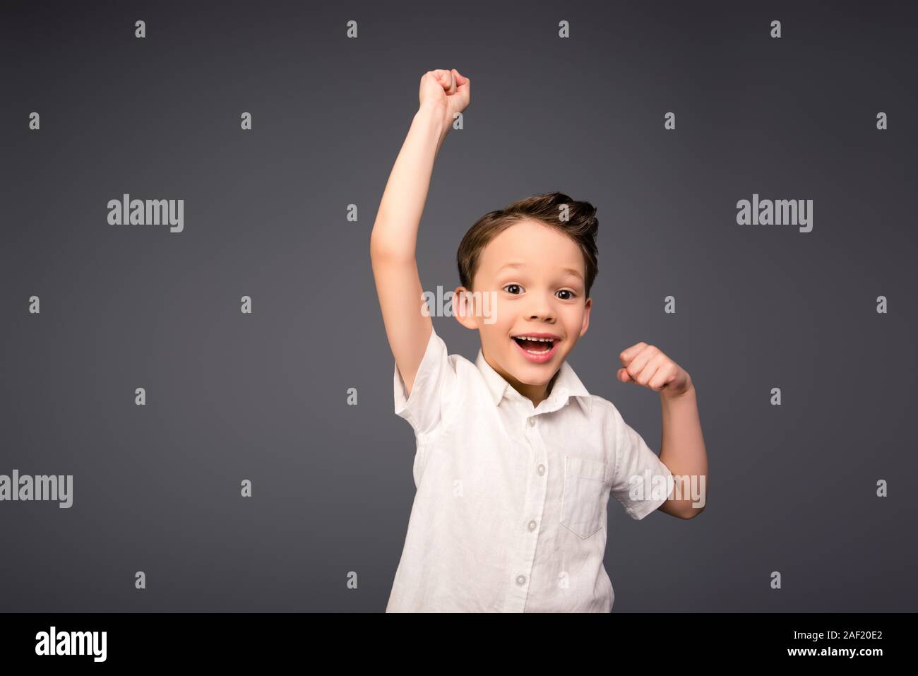 Yes! Happy little boy triumphing with raised hands Stock Photo - Alamy