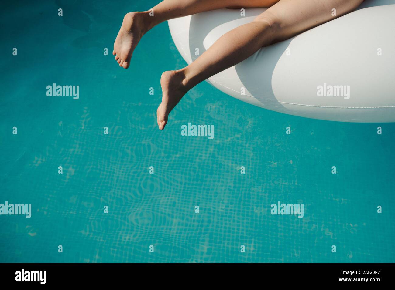 Womans legs over water in swimming-pool Stock Photo