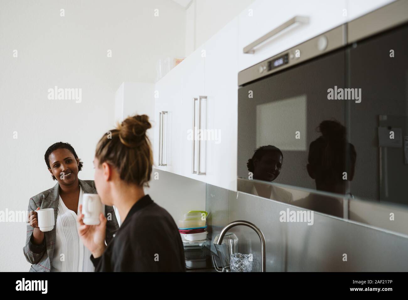 Women having coffee in kitchen Stock Photo