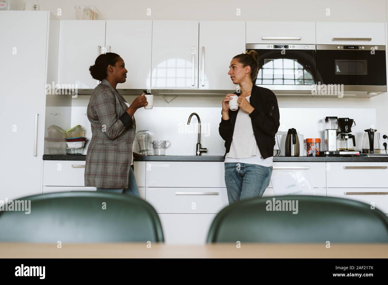Women having coffee in kitchen Stock Photo