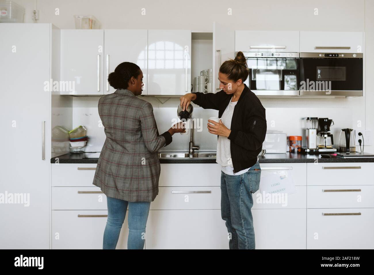 Women having coffee in kitchen Stock Photo Alamy