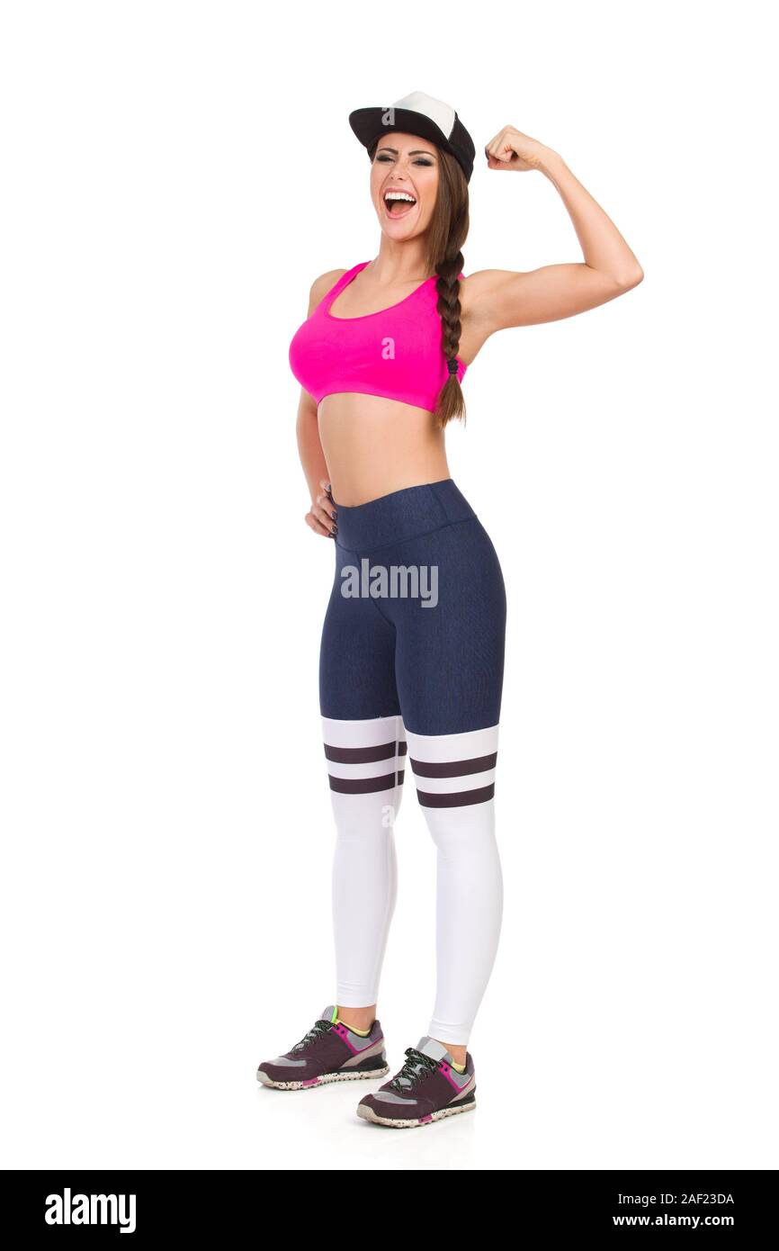 Confident fitness woman in sports clothes and baseball cap is flexing  muscle and shouting. Full length studio shot isolated on white Stock Photo  - Alamy
