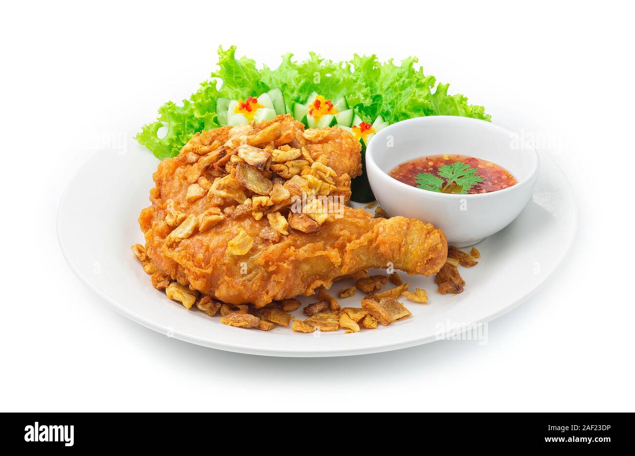 Fried Chicken Thigh Crispy Skin Topped Crispy Garlic Asian Food fusion style decorate carved cucumber Served Sweet Chili Sauce Thai Food Style side vi Stock Photo