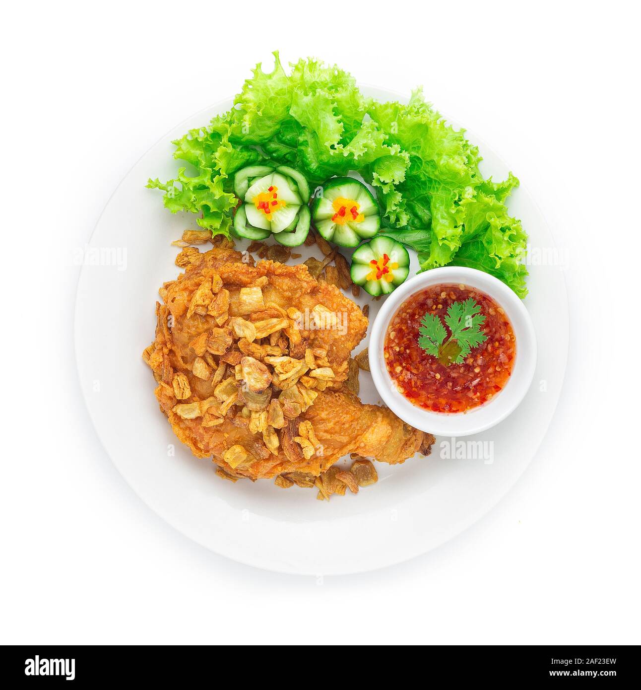 Fried Chicken Thigh Crispy Skin Topped Crispy Garlic Asian Food fusion style decorate carved cucumber Served Sweet Chili Sauce Thai Food Style side vi Stock Photo