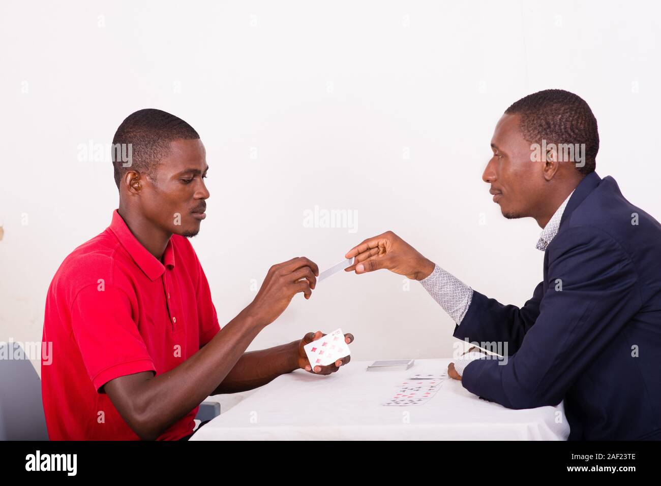 poker game between two men around a table sitting around a table with cards distributed Stock Photo