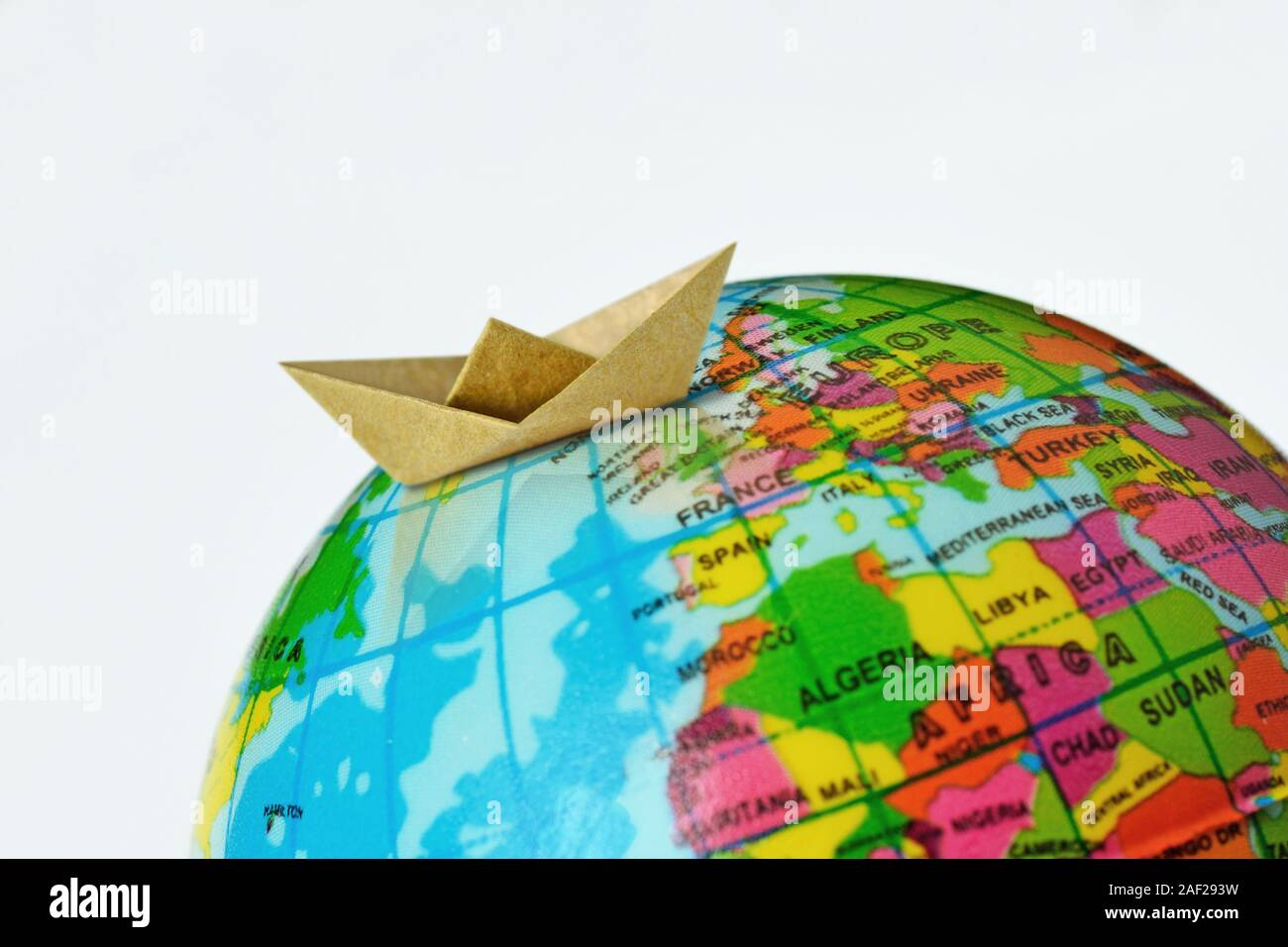 Paper boat on top of earth globe - Concept of world travel and immigration Stock Photo
