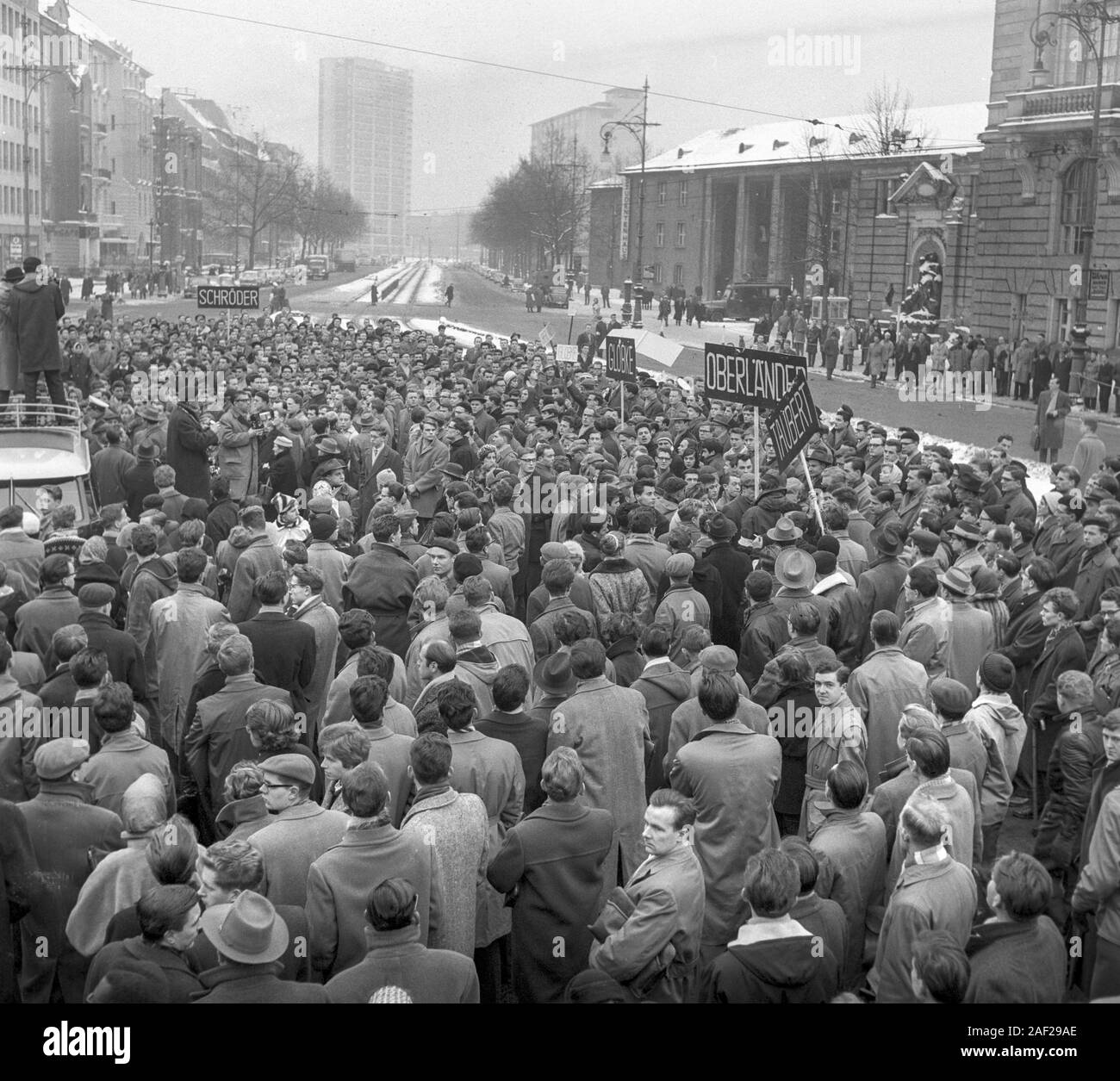A group in the crowd shows signs with names of former members of the ...