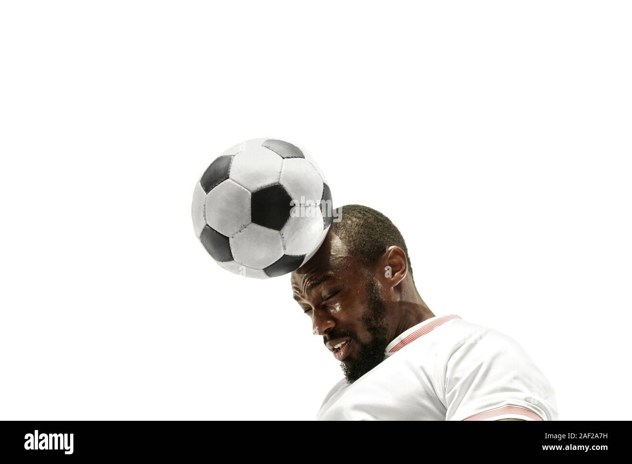 Close up of emotional african man playing soccer hitting the ball with