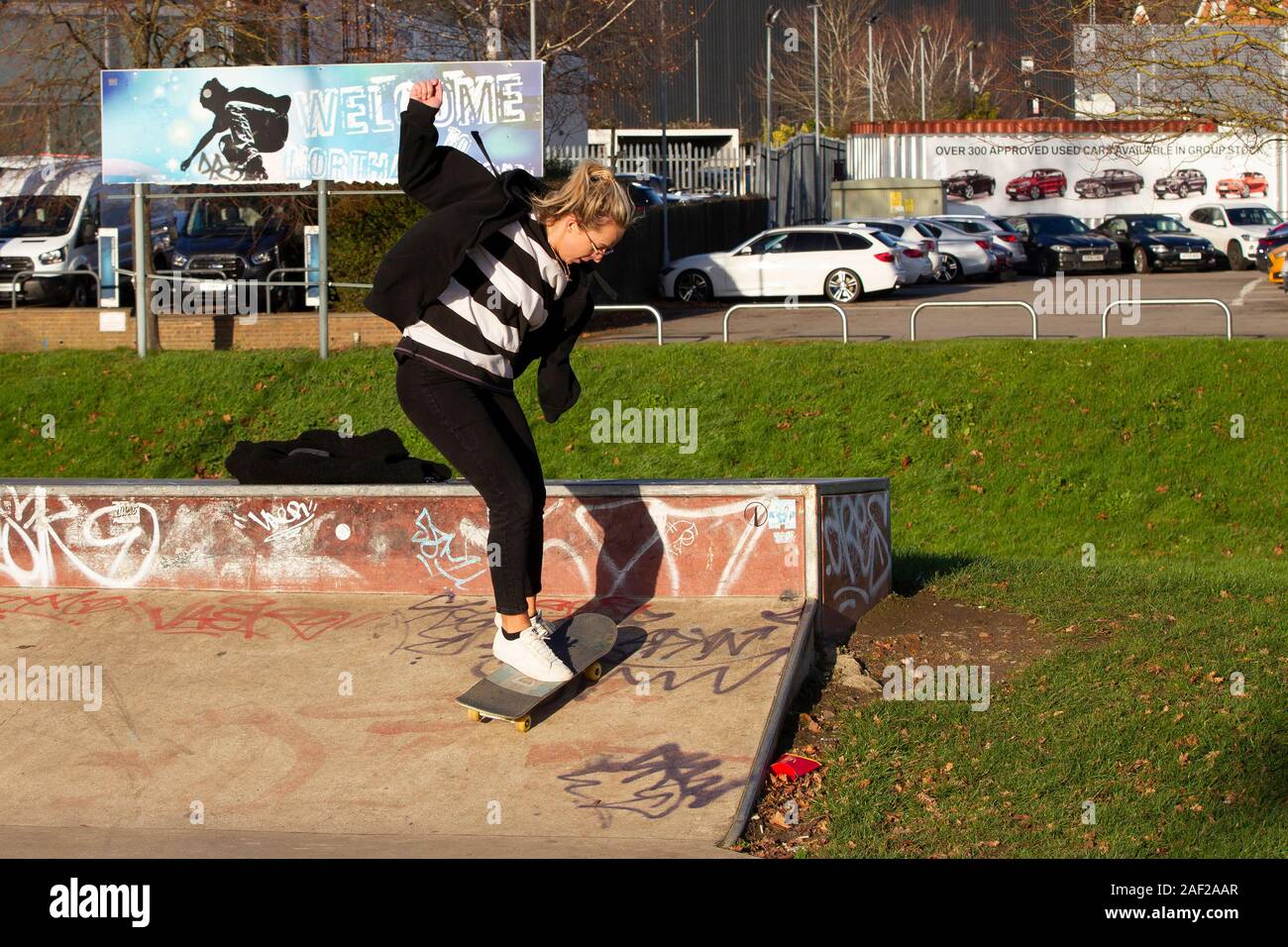 Young female boarding Radlands Skate Park, Mid Summer Meadow, Northampton, UK. Stock Photo