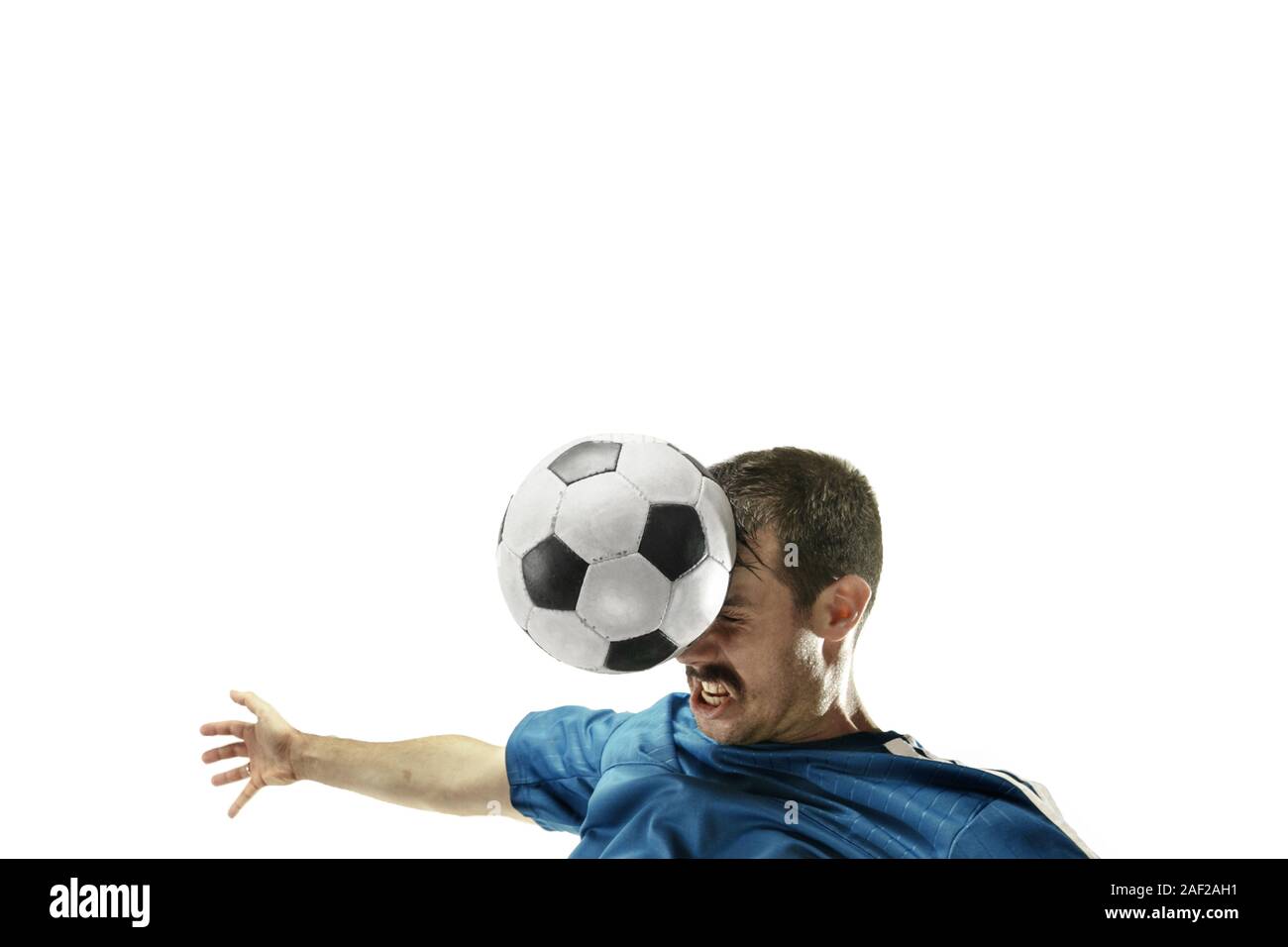 Close up of emotional caucasian man playing soccer hitting the ball